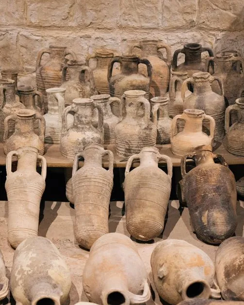 Amphores antiques en terre cuite alignées dans une salle de musée d’archéologie